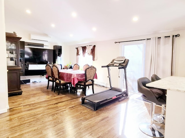 dining area with a healthy amount of sunlight, light wood-style flooring, recessed lighting, and a wall mounted AC