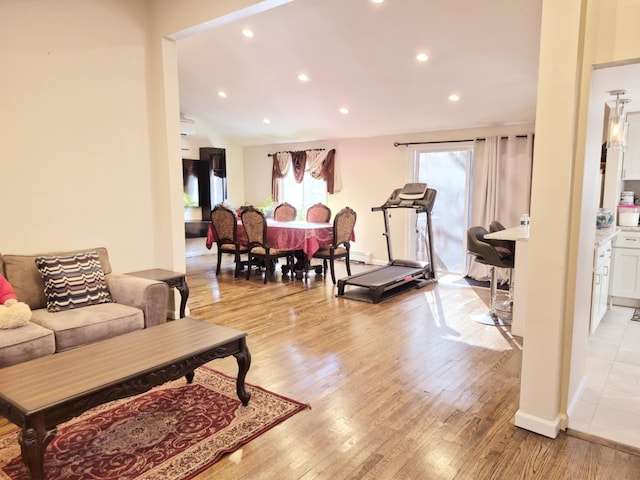 living area featuring lofted ceiling, light wood-style floors, and recessed lighting