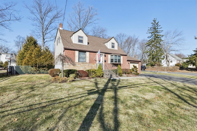 cape cod home featuring brick siding, a shingled roof, a front lawn, fence, and a chimney