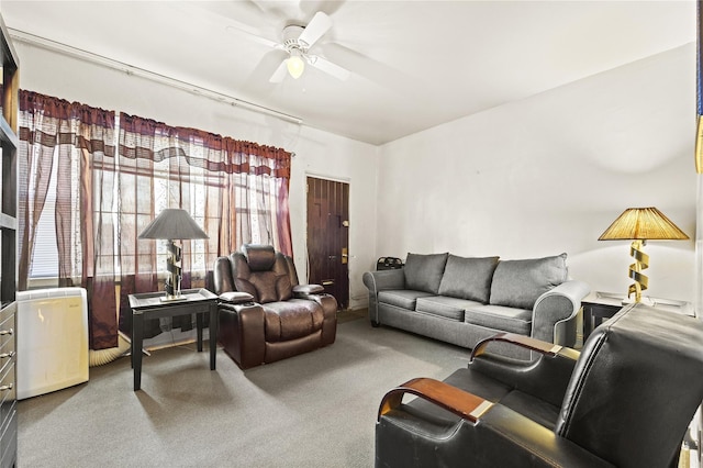 carpeted living area with a ceiling fan