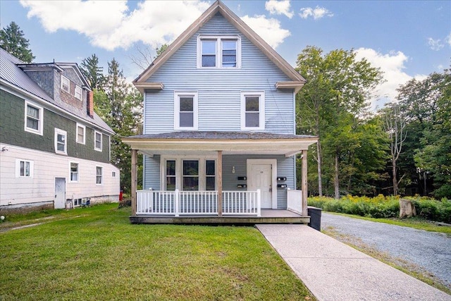 american foursquare style home with covered porch and a front lawn