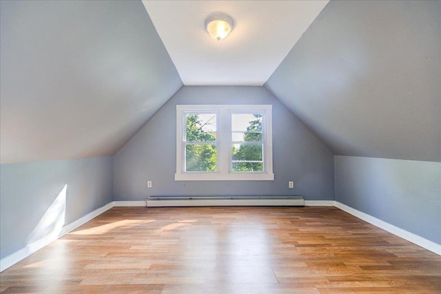 additional living space with light wood-style floors, a baseboard radiator, baseboards, and vaulted ceiling