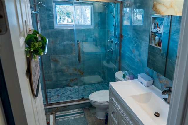 full bath with vanity, a shower stall, and toilet