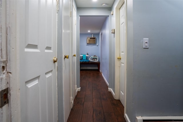 hall with baseboards, a baseboard heating unit, dark wood finished floors, and a wall mounted air conditioner