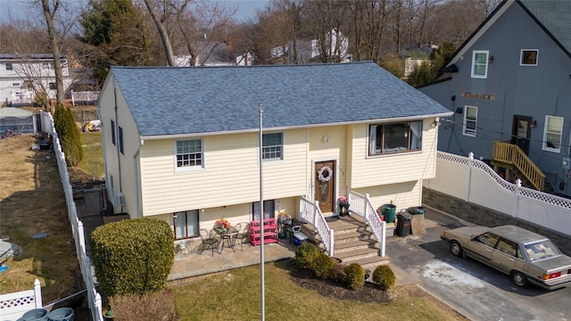 view of front of property with roof with shingles, a patio, concrete driveway, an attached garage, and fence