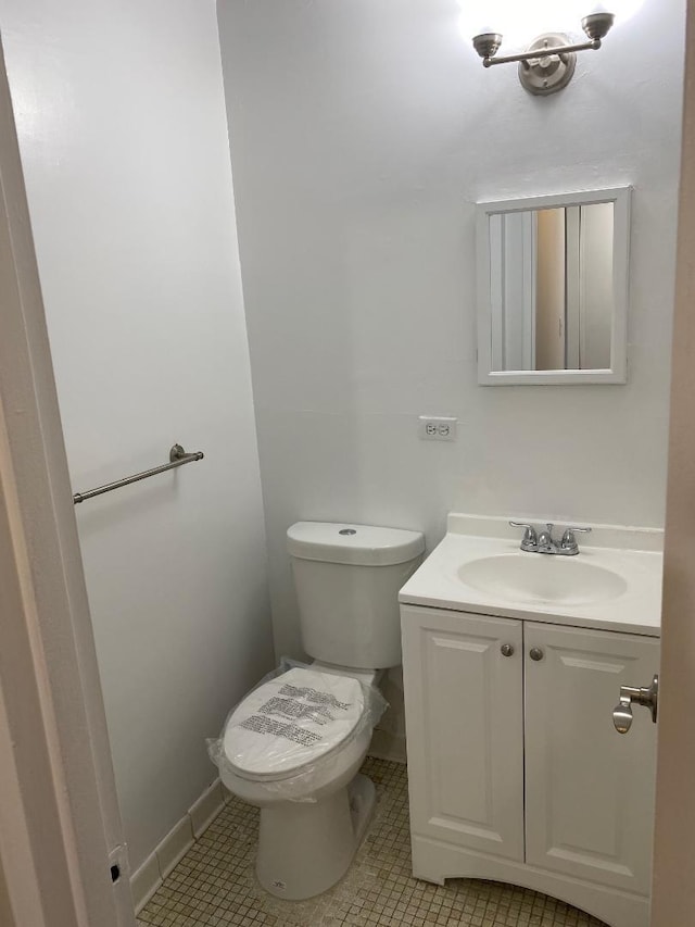 bathroom with baseboards, vanity, toilet, and tile patterned floors