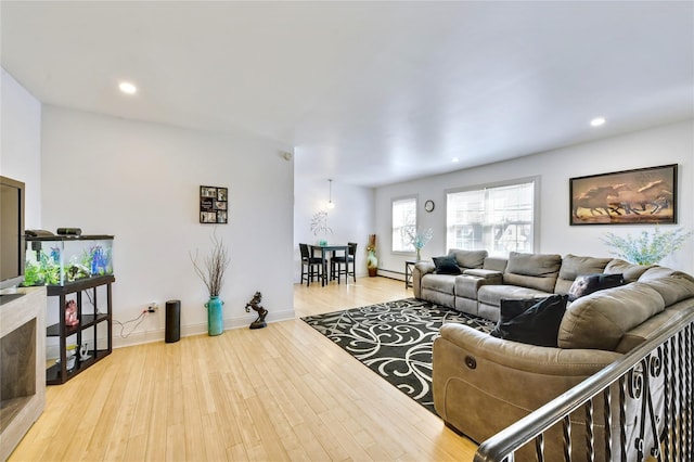 living room featuring a baseboard heating unit, baseboards, wood finished floors, and recessed lighting