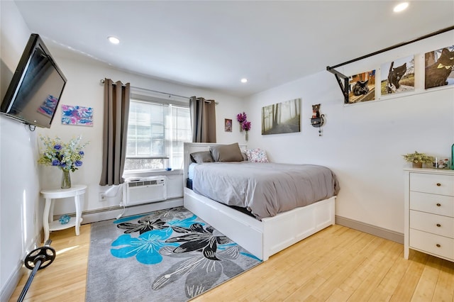 bedroom with recessed lighting, a baseboard heating unit, baseboards, a wall mounted AC, and light wood finished floors