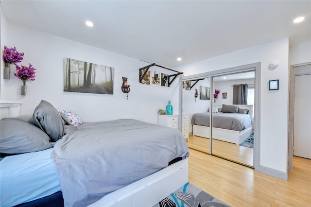 bedroom featuring light wood-style flooring, a closet, and recessed lighting