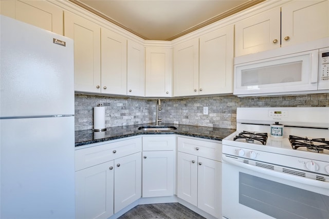 kitchen with white appliances, dark stone counters, backsplash, and a sink