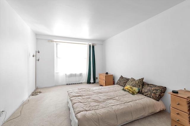 bedroom with light colored carpet and radiator heating unit