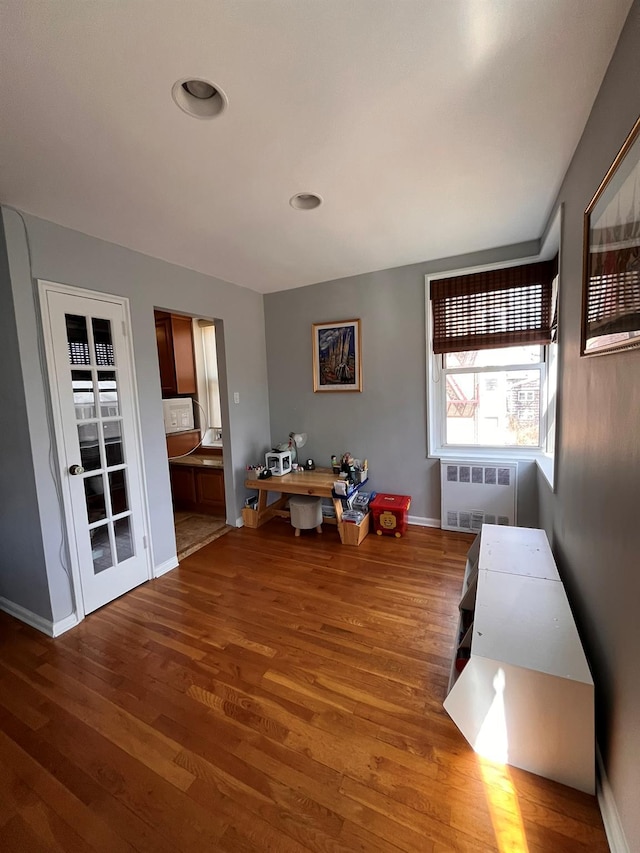 interior space featuring baseboards, radiator heating unit, and wood finished floors