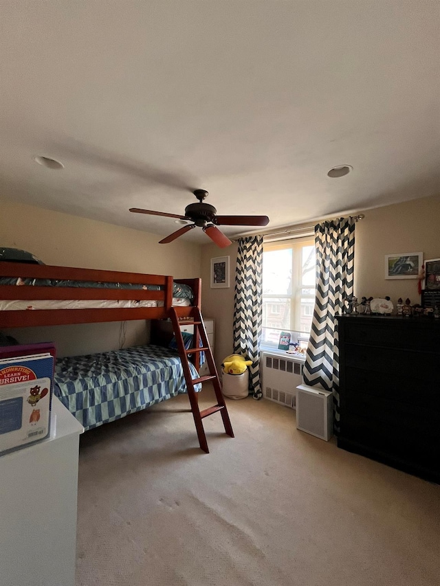 carpeted bedroom featuring radiator heating unit and a ceiling fan