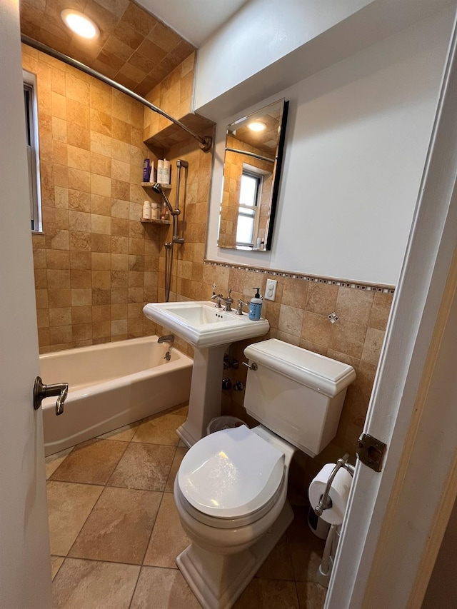 full bath with shower / bath combination, a sink, tile walls, and toilet