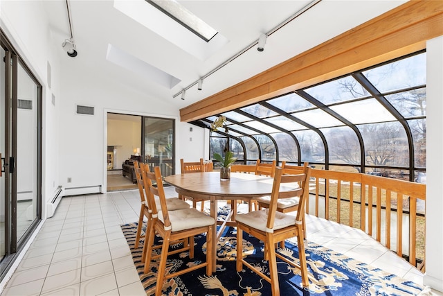 sunroom / solarium with lofted ceiling with skylight, track lighting, visible vents, and a baseboard heating unit