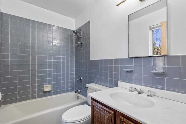 bathroom with washtub / shower combination, vanity, toilet, and tile walls