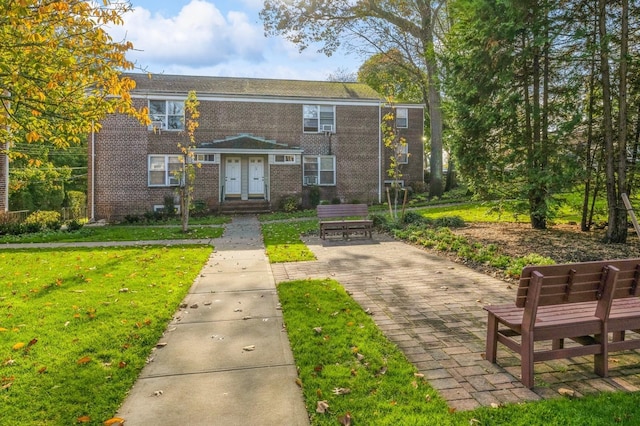 view of front of home featuring a front lawn and brick siding