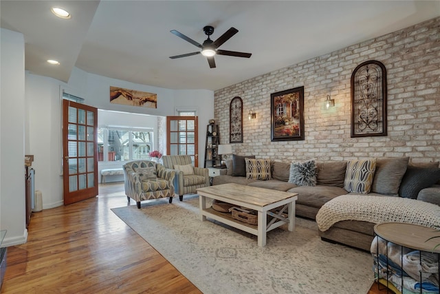 living area featuring recessed lighting, a ceiling fan, brick wall, wood finished floors, and baseboards