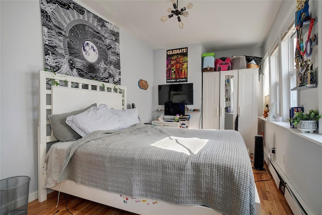 bedroom featuring baseboard heating and wood finished floors