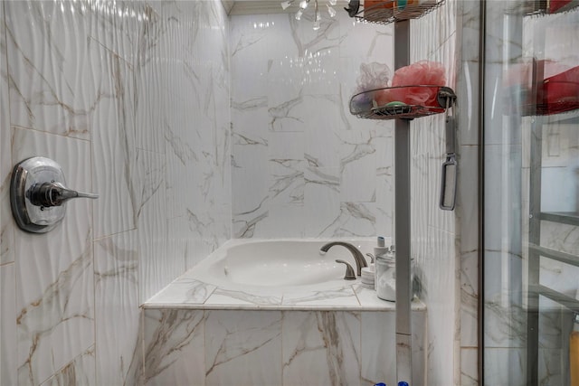 bathroom with a sink, a tub with marble appearance, and a marble finish shower