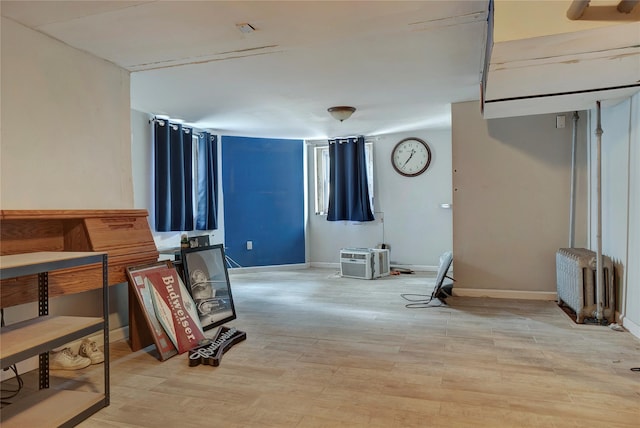 interior space featuring baseboards, light wood finished floors, and radiator