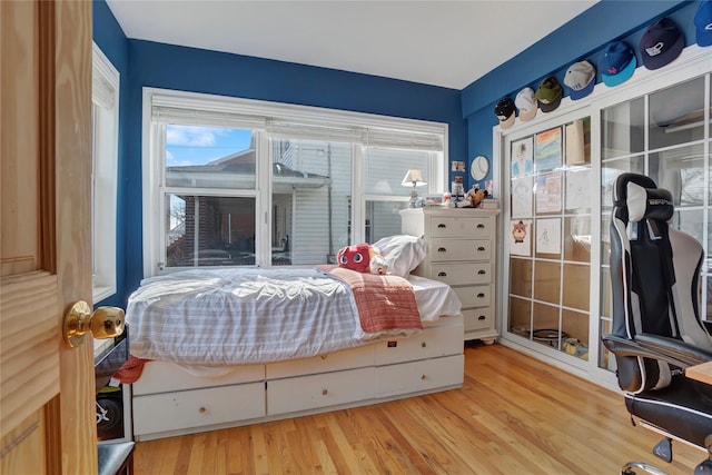 bedroom with multiple windows and wood finished floors