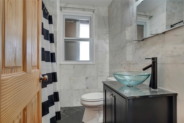 bathroom featuring toilet, tile patterned floors, curtained shower, vanity, and tile walls