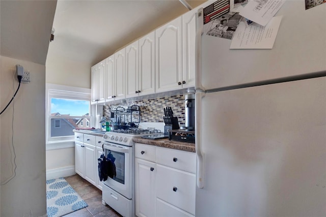 kitchen featuring white appliances, dark countertops, backsplash, and white cabinetry