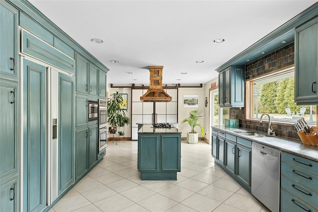 kitchen with appliances with stainless steel finishes, a center island, a sink, and green cabinets