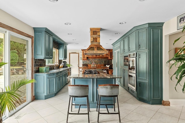 kitchen with light tile patterned floors, island range hood, and green cabinetry