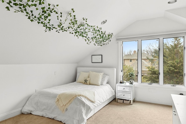 bedroom with multiple windows, vaulted ceiling, and light carpet