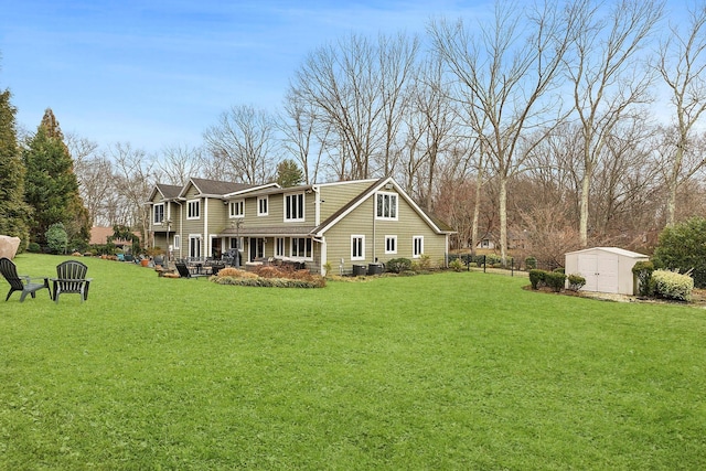 rear view of house featuring an outbuilding, central AC unit, a storage shed, fence, and a lawn