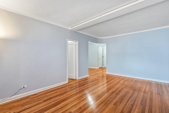 unfurnished room with hardwood / wood-style floors and baseboards