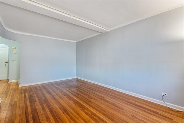 empty room featuring hardwood / wood-style flooring and baseboards