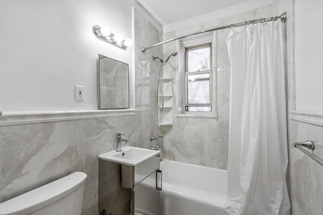 bathroom featuring a wainscoted wall, shower / bath combination with curtain, toilet, and tile walls