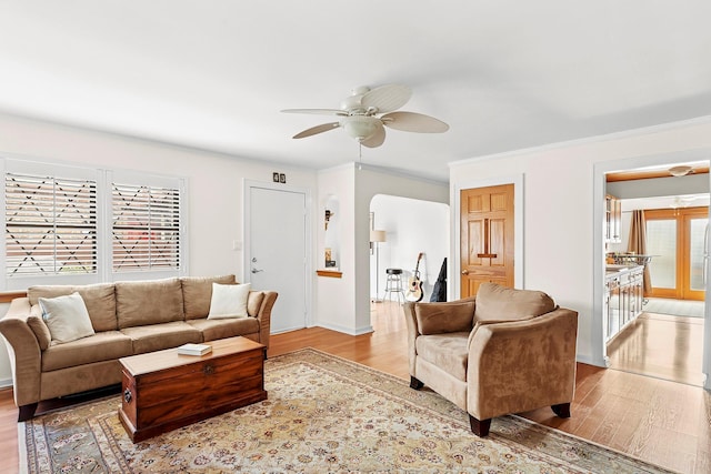 living area featuring a wealth of natural light, light wood-type flooring, and a ceiling fan