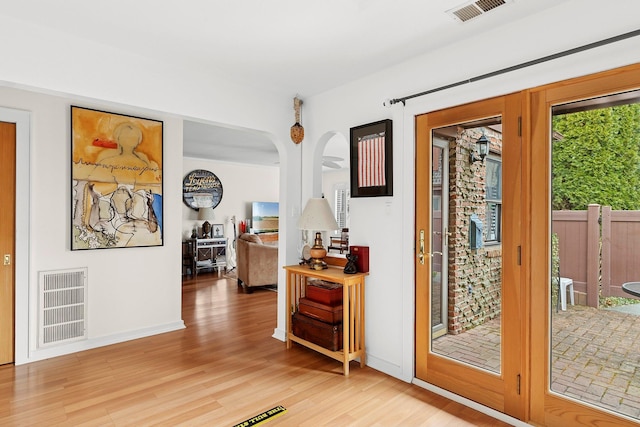 entryway with light wood-style floors, baseboards, and visible vents