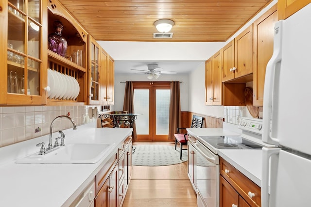 kitchen with white appliances, visible vents, wooden ceiling, light countertops, and a sink