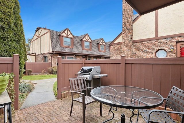 view of patio featuring outdoor dining space, fence, and area for grilling