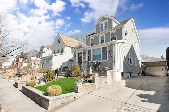 traditional style home with a garage, a residential view, and an outbuilding