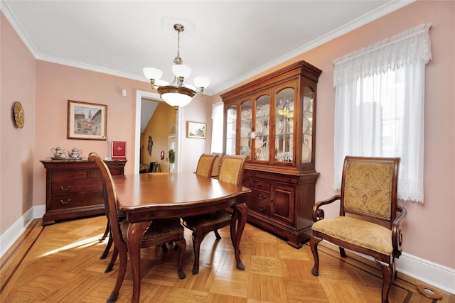 dining space featuring crown molding, baseboards, and a notable chandelier