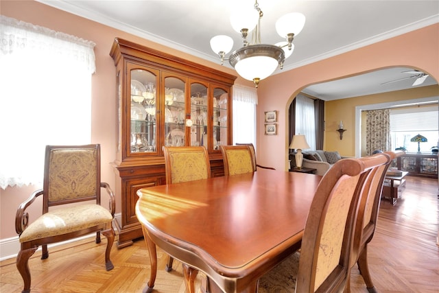 dining space with ornamental molding, arched walkways, and ceiling fan with notable chandelier