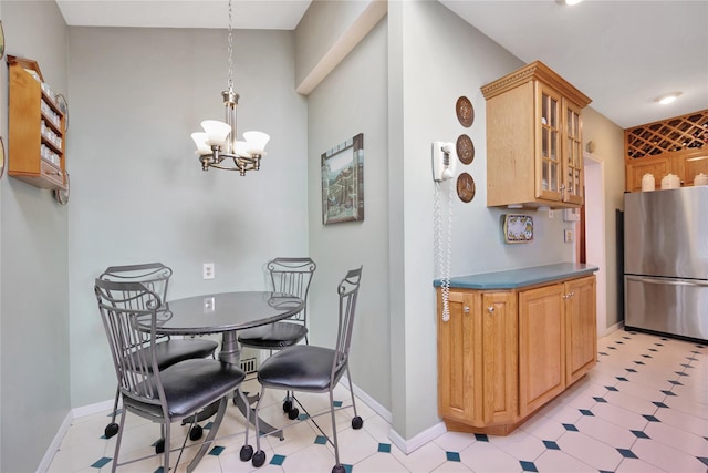 dining room with baseboards, light floors, and a notable chandelier