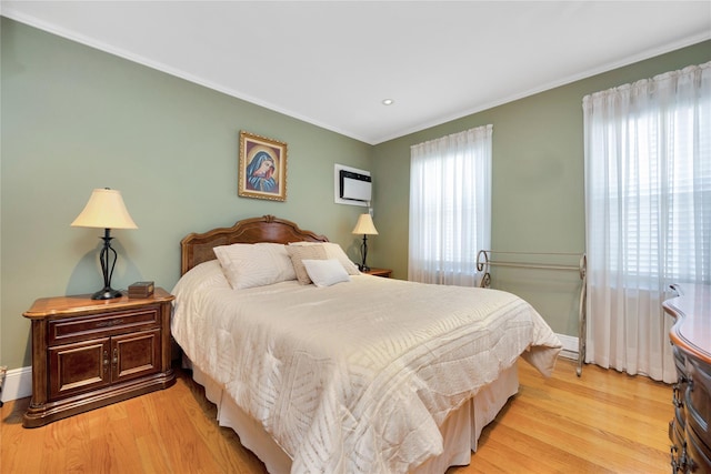 bedroom with light wood-style floors, recessed lighting, crown molding, and baseboards