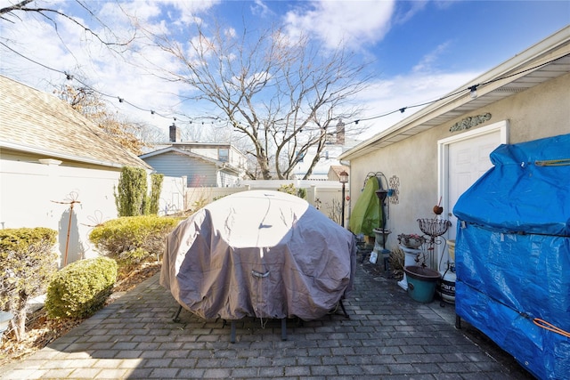 view of patio with a grill and fence