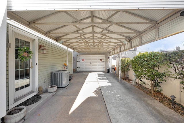 view of vehicle parking featuring a garage, fence, a carport, and concrete driveway