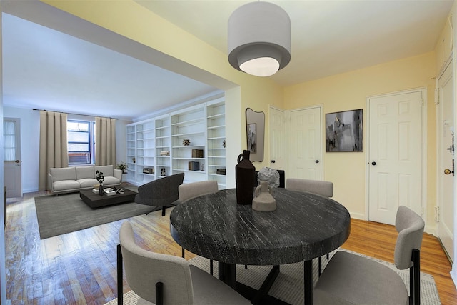 dining area with light wood-style flooring and baseboards