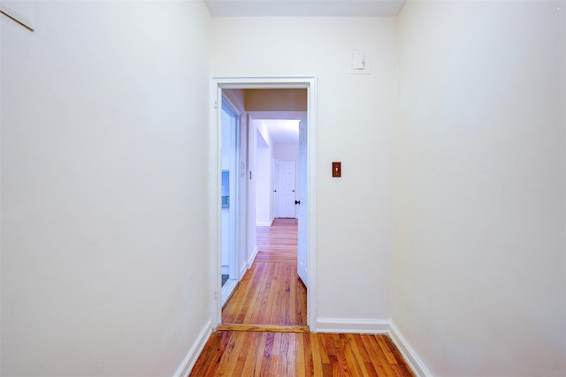 hall featuring baseboards and light wood-style floors