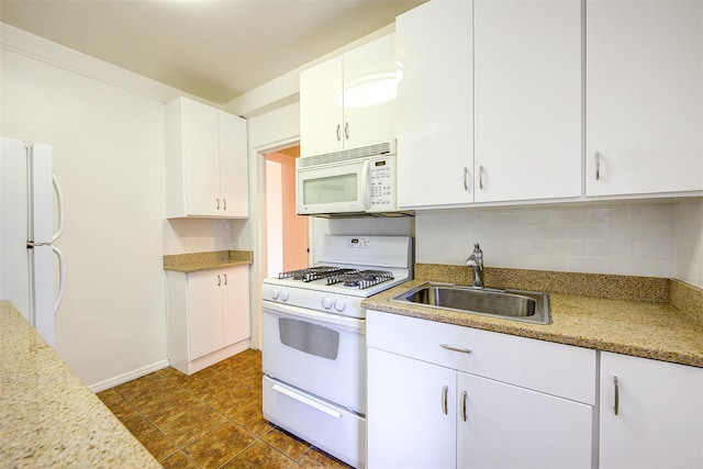 kitchen featuring tasteful backsplash, light countertops, white cabinets, a sink, and white appliances