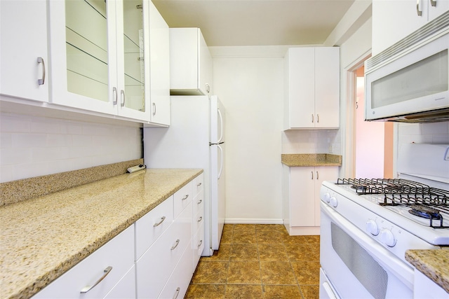 kitchen with glass insert cabinets, white appliances, white cabinetry, and backsplash